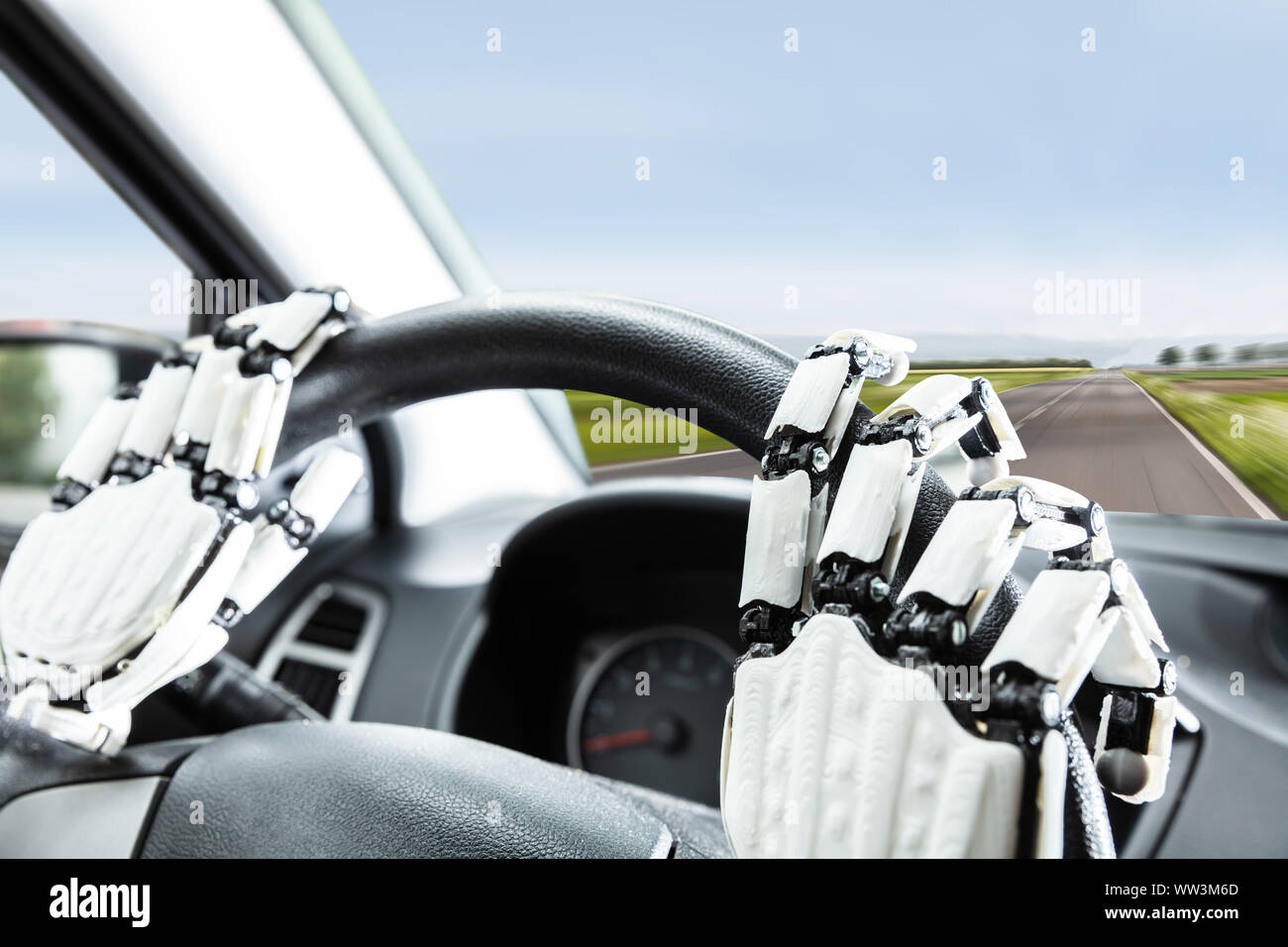 Nahaufnahme der Robotic Hand auf's Auto Lenkrad Stockfoto