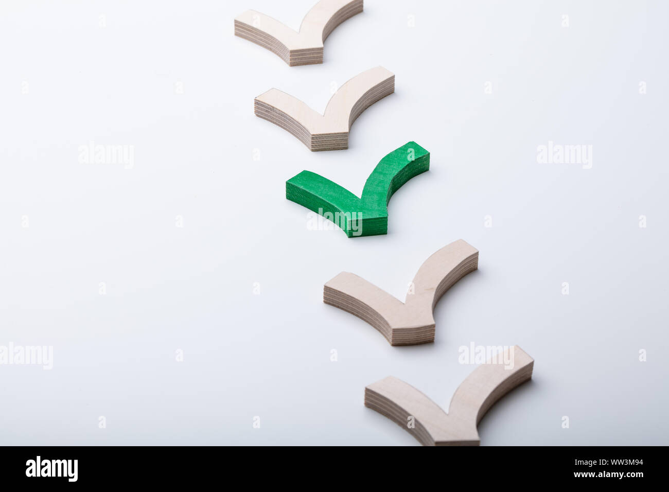 Grüne Markierung Zeichen in der Zeile der hölzernen Häkchen Zeichen isoliert auf weiße Oberfläche Stockfoto