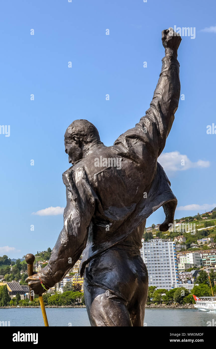 Montreux, Schweiz - 26. Juli 2019: berühmte Statue von Freddie Mercury, der Sänger der berühmten Band Queen. Stadt durch den Genfer See im Hintergrund. Beliebte touristische Sehenswürdigkeit. Freddy Mercury, Farrokh Bulsara. Stockfoto