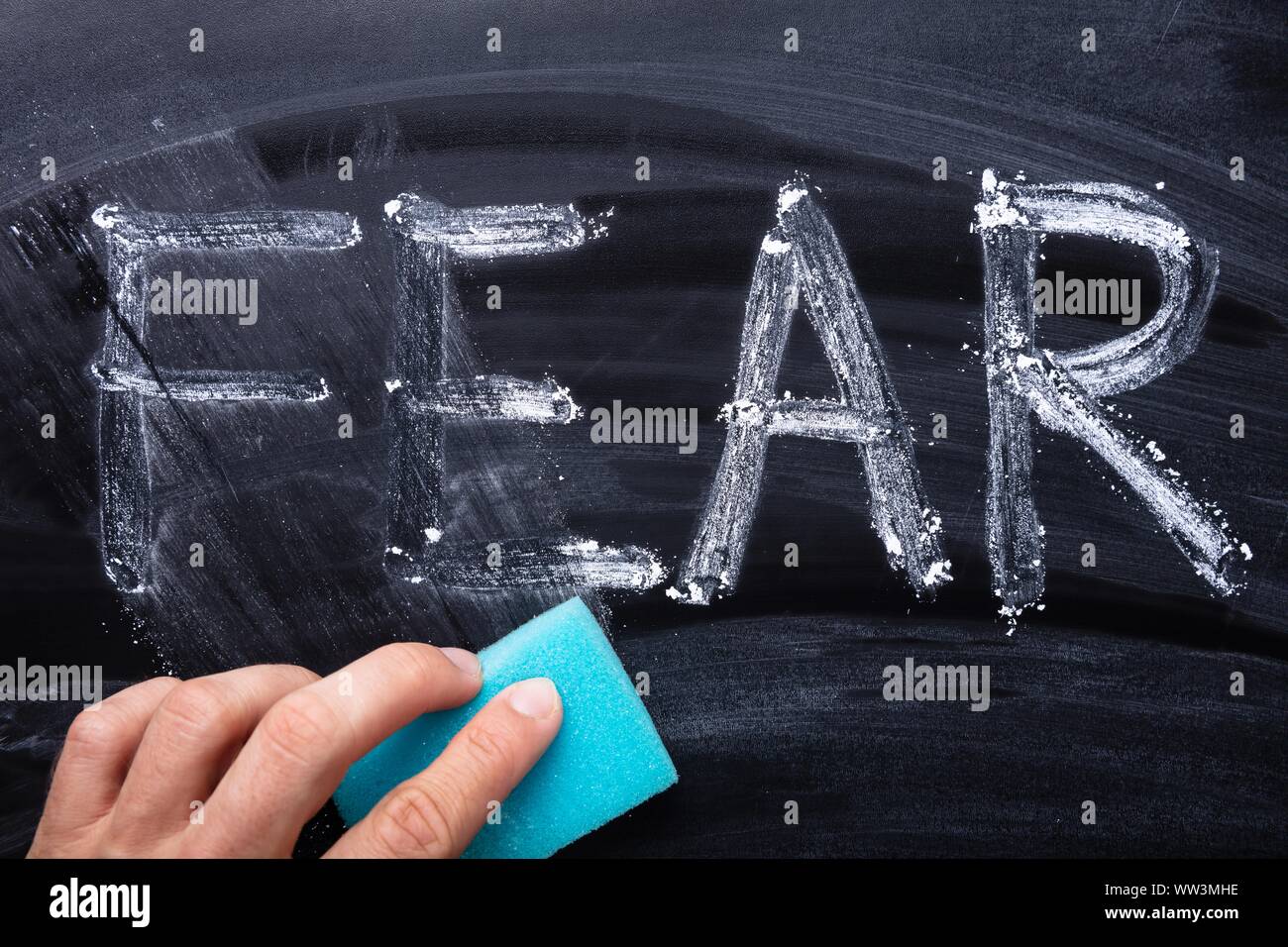 In der Nähe von Hand löschen Angst Wort mit blauen Schwamm auf Blackboard Stockfoto
