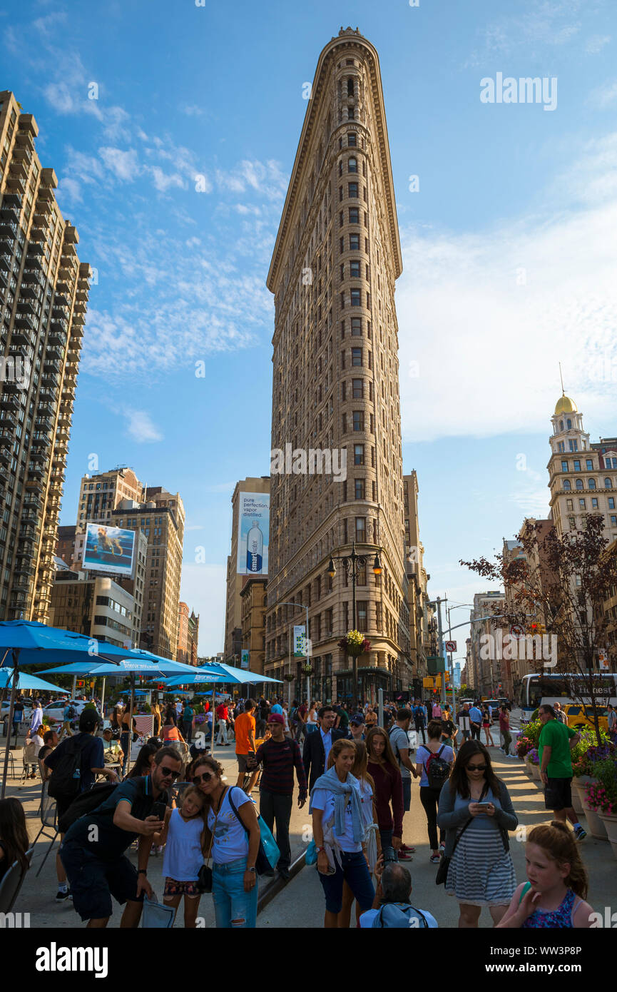 NEW YORK - 11. AUGUST 2017: Besucher nehmen selfies vor dem Flatiron Building, einer der ersten und berühmtesten Wolkenkratzer der Stadt. Stockfoto