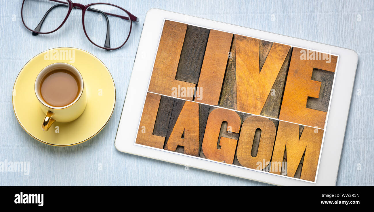 Live lagom word Abstract in Vintage buchdruck Holz Bausteine, Flachbild ley mit einem digitalen Tablet und Kaffee, lagom ist der Schwedische, ausgewogenen Lebensstil c Stockfoto