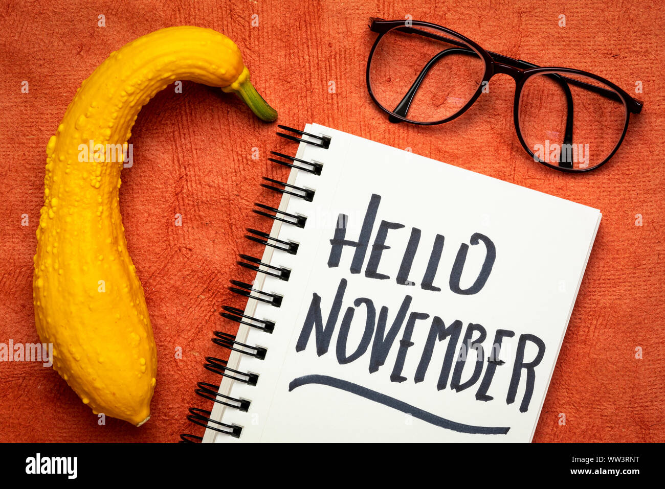 Hallo November - fröhlich Handschrift in einem Notebook mit einem dekorativen Kürbis Stockfoto