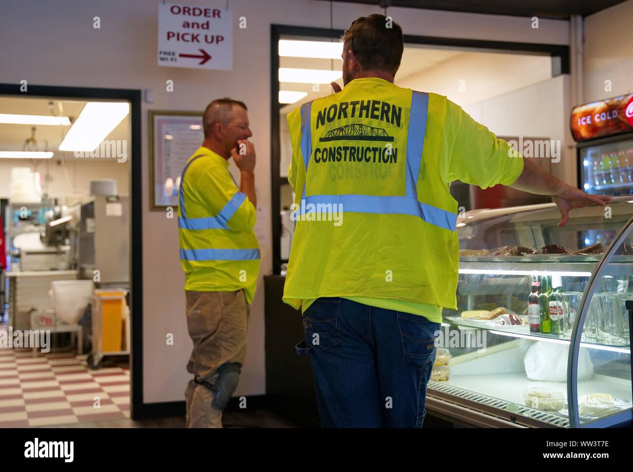 Rocky Hill, CT USA. Aug 2019. Hungrige Bauarbeiter mit reflektierenden Warnwesten erhalten ein Mittagessen in einem lokalen Restaurant. Stockfoto