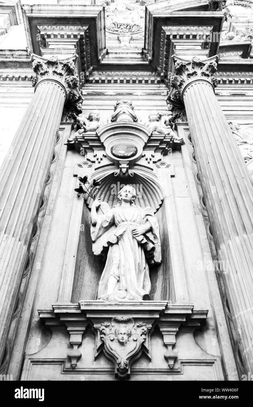 Ein schwarz-weißes Bild von der Außenseite einer Kirche in Granada, Spanien. Mit einer religiösen Figur und religiösen Symbolik. Stockfoto