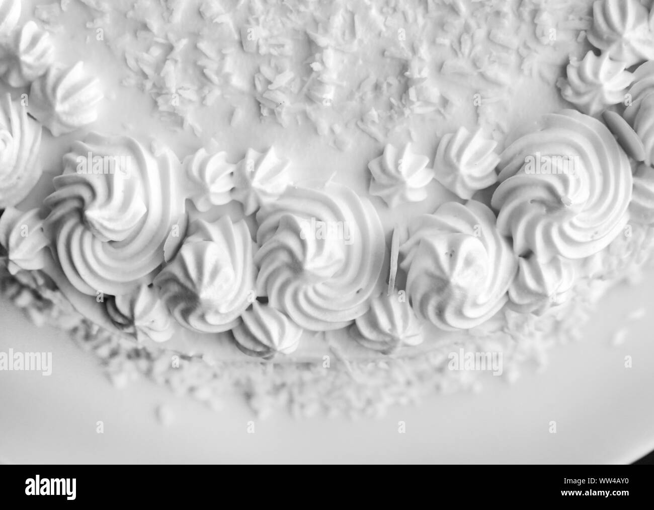 Hausgemachte Kuchen (Raffaello Kokos Mandel Kuchen) in einer Nahaufnahme. Mit weisser Schlagsahne, Kokos und mandelblättchen eingerichtet. Wunderschöne, detaillierte Gebäck. Stockfoto