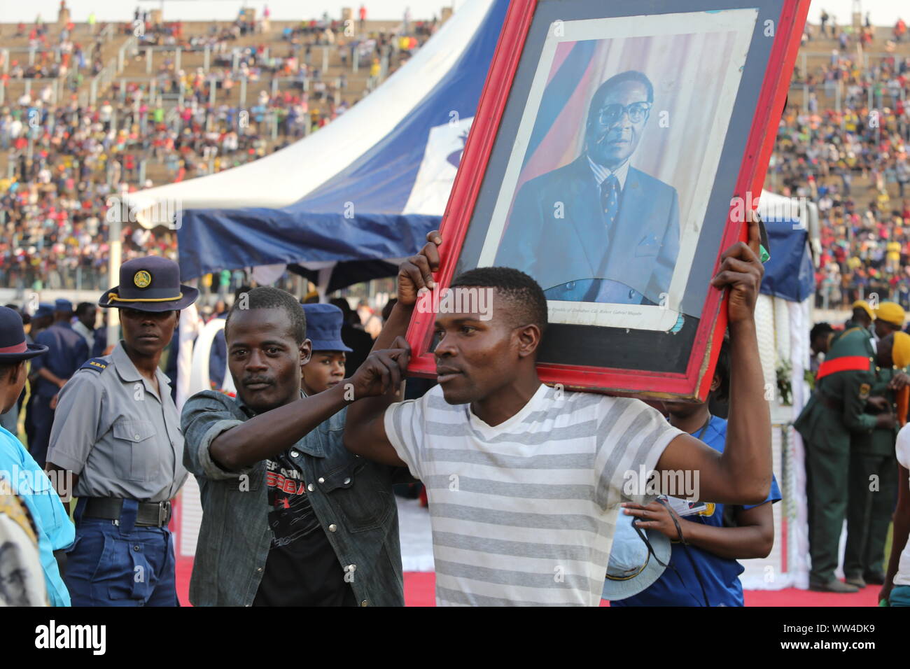 Peking, China. 12 Sep, 2019. Ein Mann hält spät Simbabwes Präsident Robert Mugabe's Portrait nach Respekt zu Mugabe in Harare Sept. 12, 2019. Tausende von Menschen in Simbabwe zu Rufaro Stadion unter der Leitung von Robert Mugabe in Harare am Donnerstag zu sehen, markieren die erste einer Serie von öffentlichen Trauerfeier bis Samstag gefüttert. Credit: Chen Yaqin/Xinhua Stockfoto