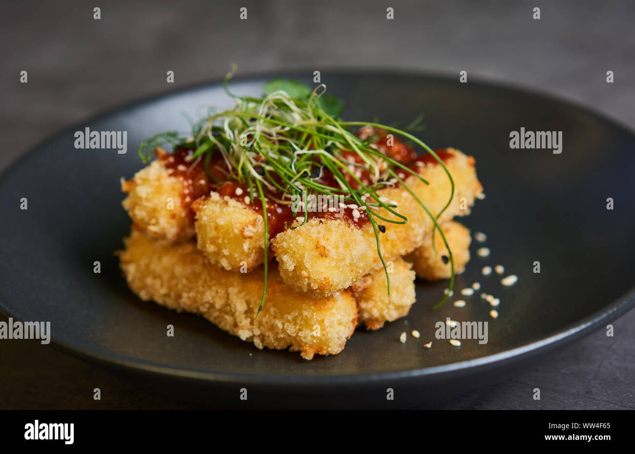 Panierte Käsestange mit Sauce auf einer Platte Stockfoto