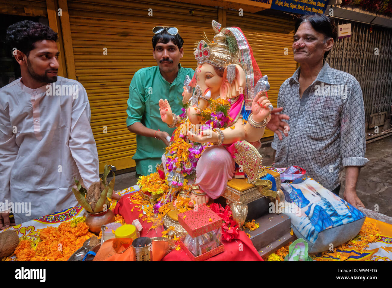 Während der Ganesh Festival Prozession in Mumbai, Indien, Anbeter der Elefantengott Ganesh (Ganpati) drücken Sie auf einem Wagen mit einem Ganesh Statue Stockfoto