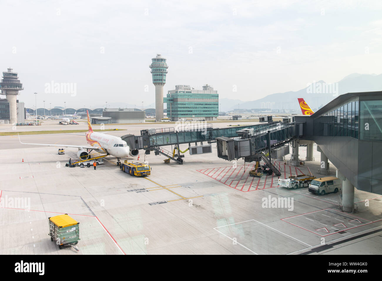 Hongkong Airlines Flugzeug dock bridge Passagier von Terminal an der Start- und Landebahn Park Hong Kong International Airport zu übertragen. Hongkong, den 24. November Stockfoto