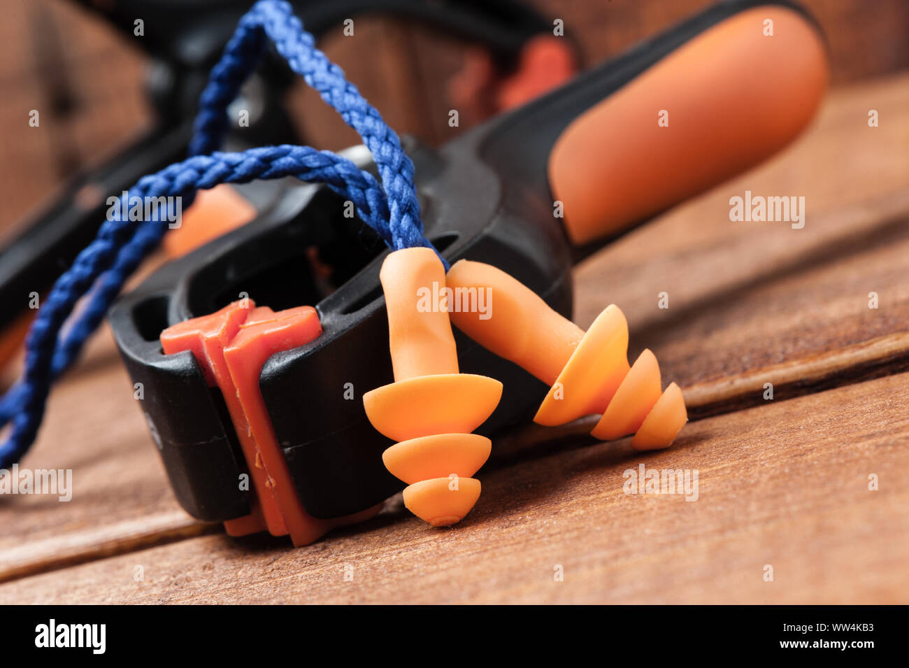 Orange Wiederverwendbare Gehörschutzstöpsel über Holz Hintergrund, Personenschutzanlagen Stockfoto