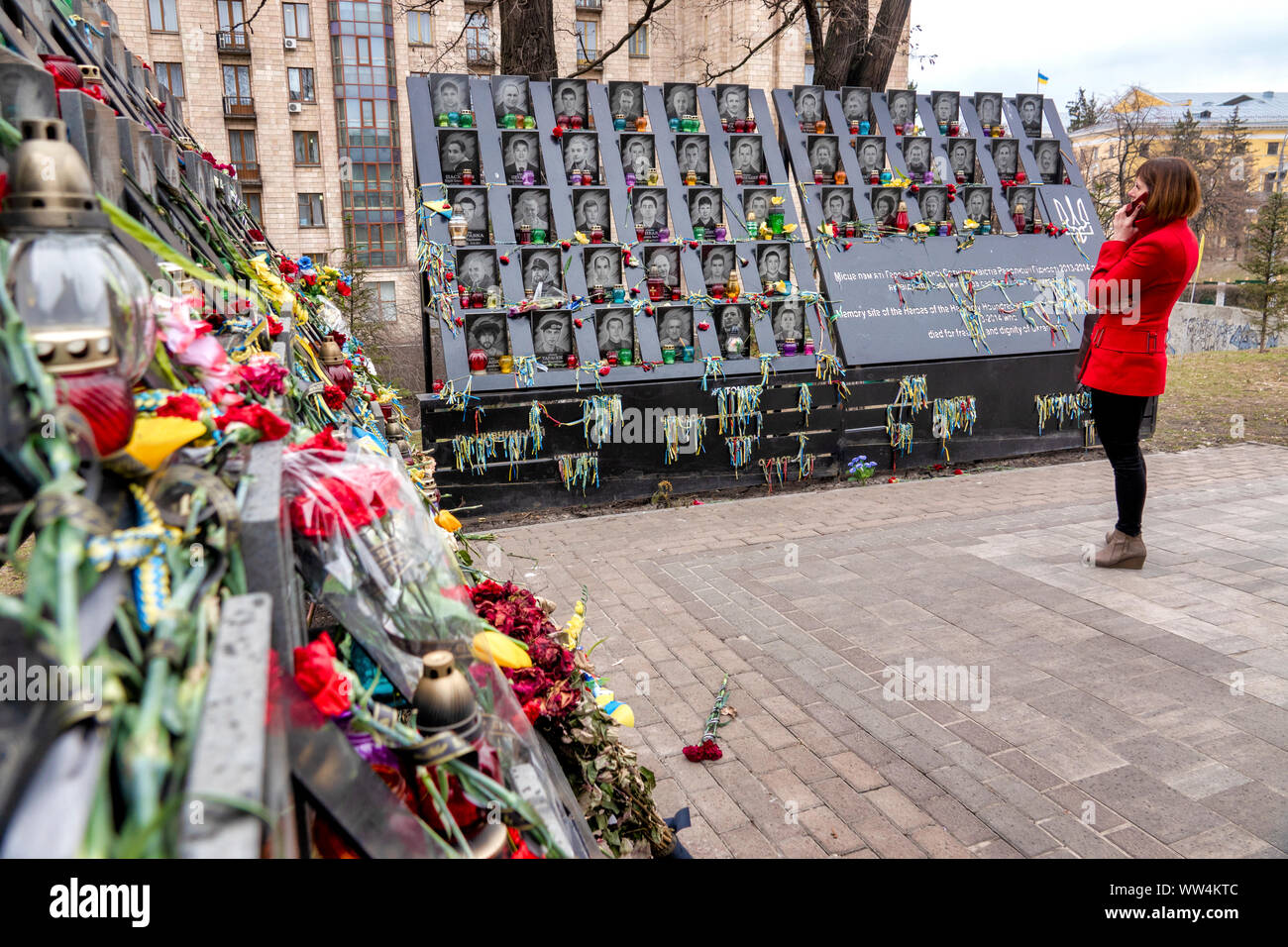 Frau im roten Mantel, die vor dem Euromaidan-Denkmal in Kiew, Ukraine, steht Stockfoto