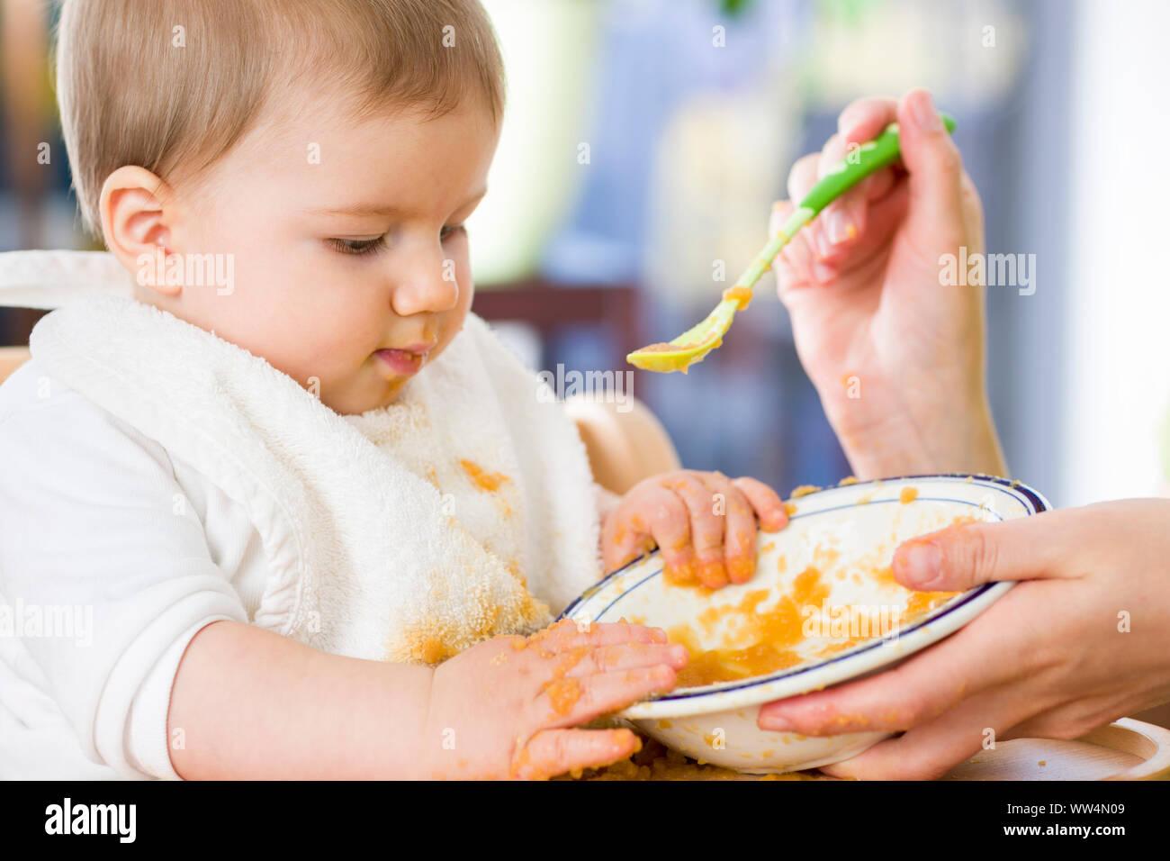 Sweet messy baby boy Mit Essen spielen beim Essen. Stockfoto