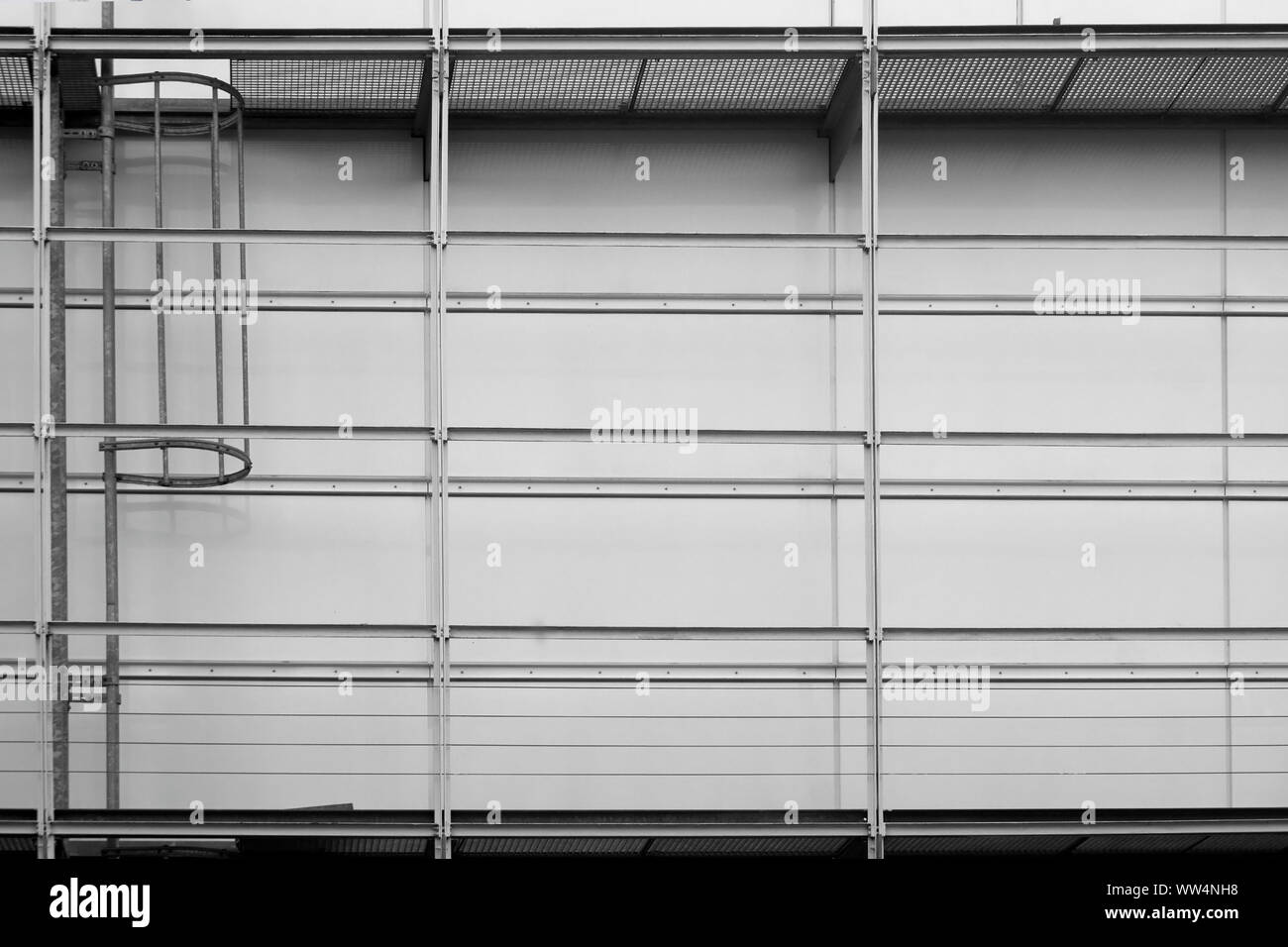 Fotografie der Dose an der Wand an einem öffentlichen Gebäude mit einem begehbaren Gerüste und eine Feuerleiter, Stockfoto