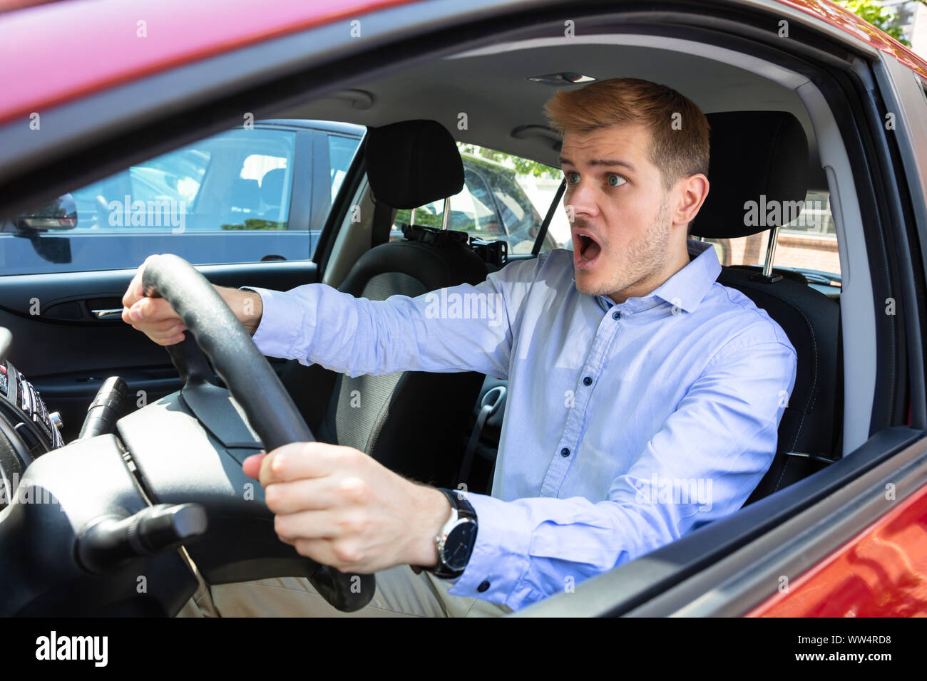 Porträt eines jungen Mannes entsetzt Auto Stockfoto