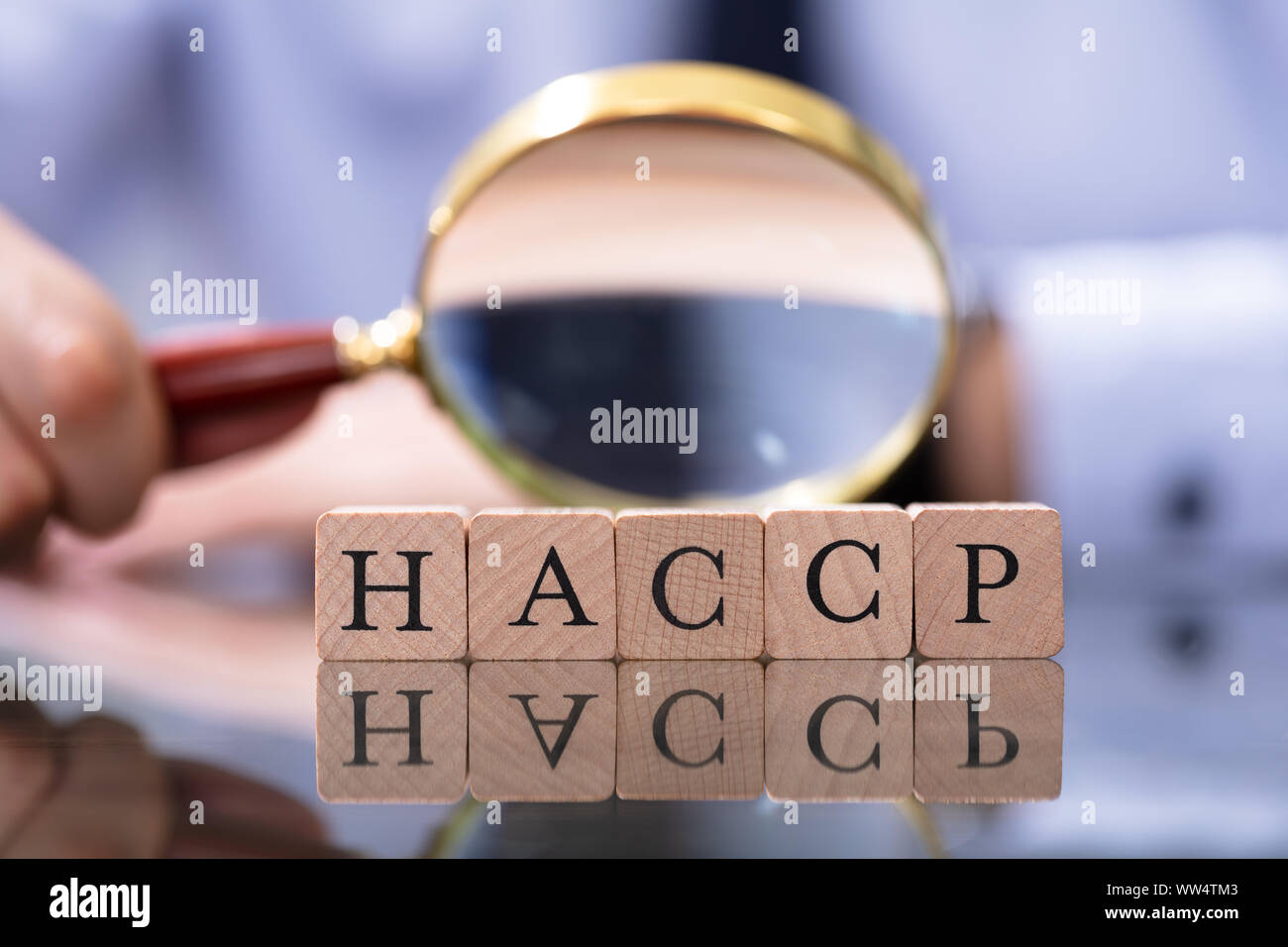 Der Mensch auf der Suche nach HACCP-Briefe mit Lupe Stockfoto