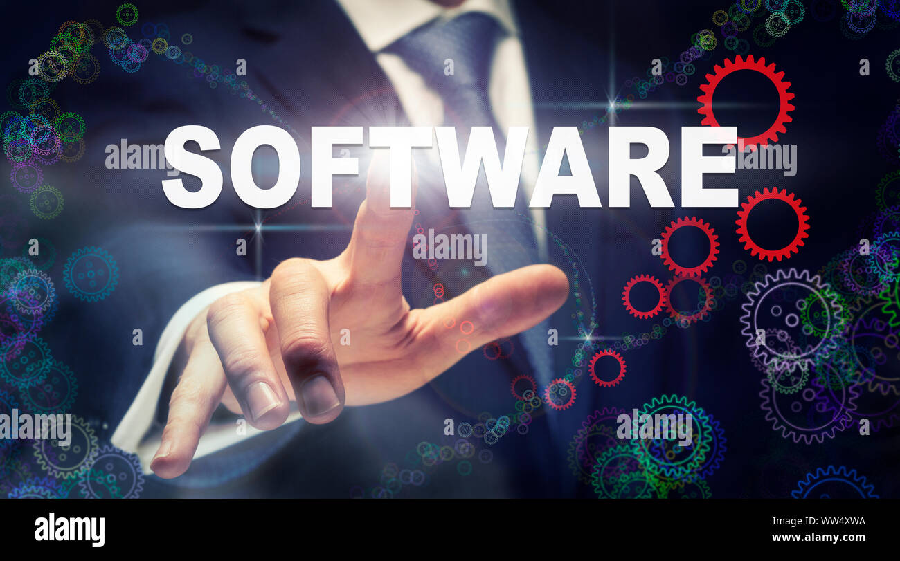 Ein Geschäftsmann Drücken einer Software Business Konzept, das auf einer grafischen Darstellung der Zahnräder Stockfoto