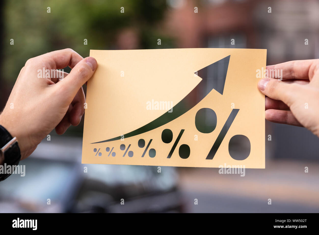 Hände, die Papier mit Ausschnitt Prozent Wachstum im Freien Stockfoto