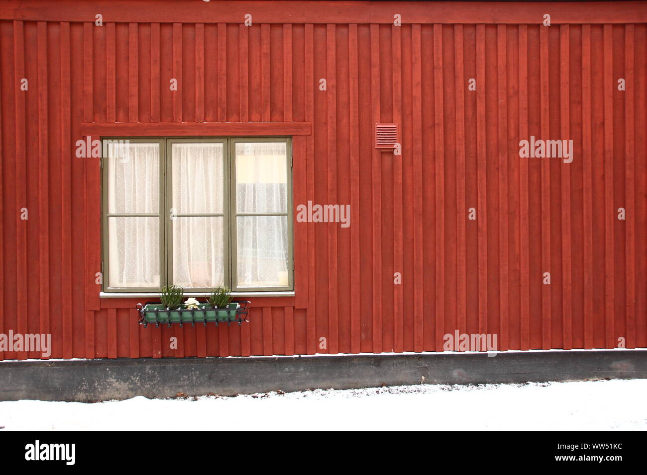 Ein Fenster mit kleinen Fenster Box zu einem typisch schwedischen Haus Fassade in roter Farbe, Stockfoto