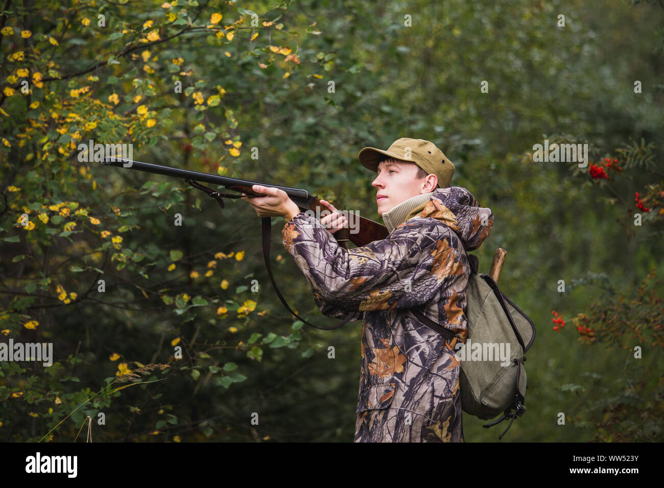 Jäger mit einen Rucksack und eine Jagd Gewehr in den Wald. Stockfoto