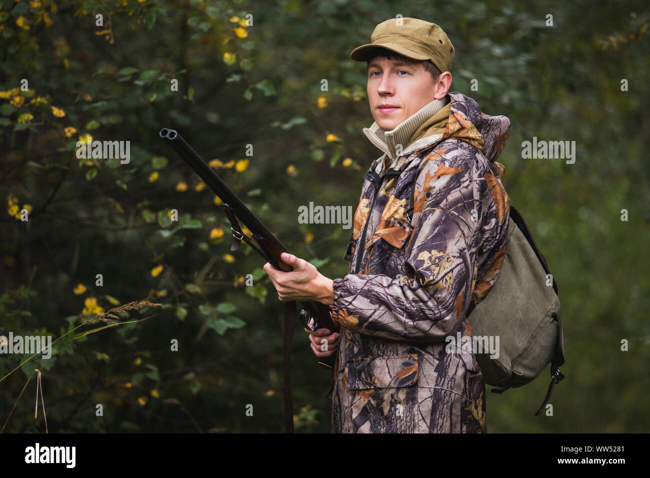 Jäger mit einen Rucksack und eine Jagd Gewehr in den Wald. Stockfoto