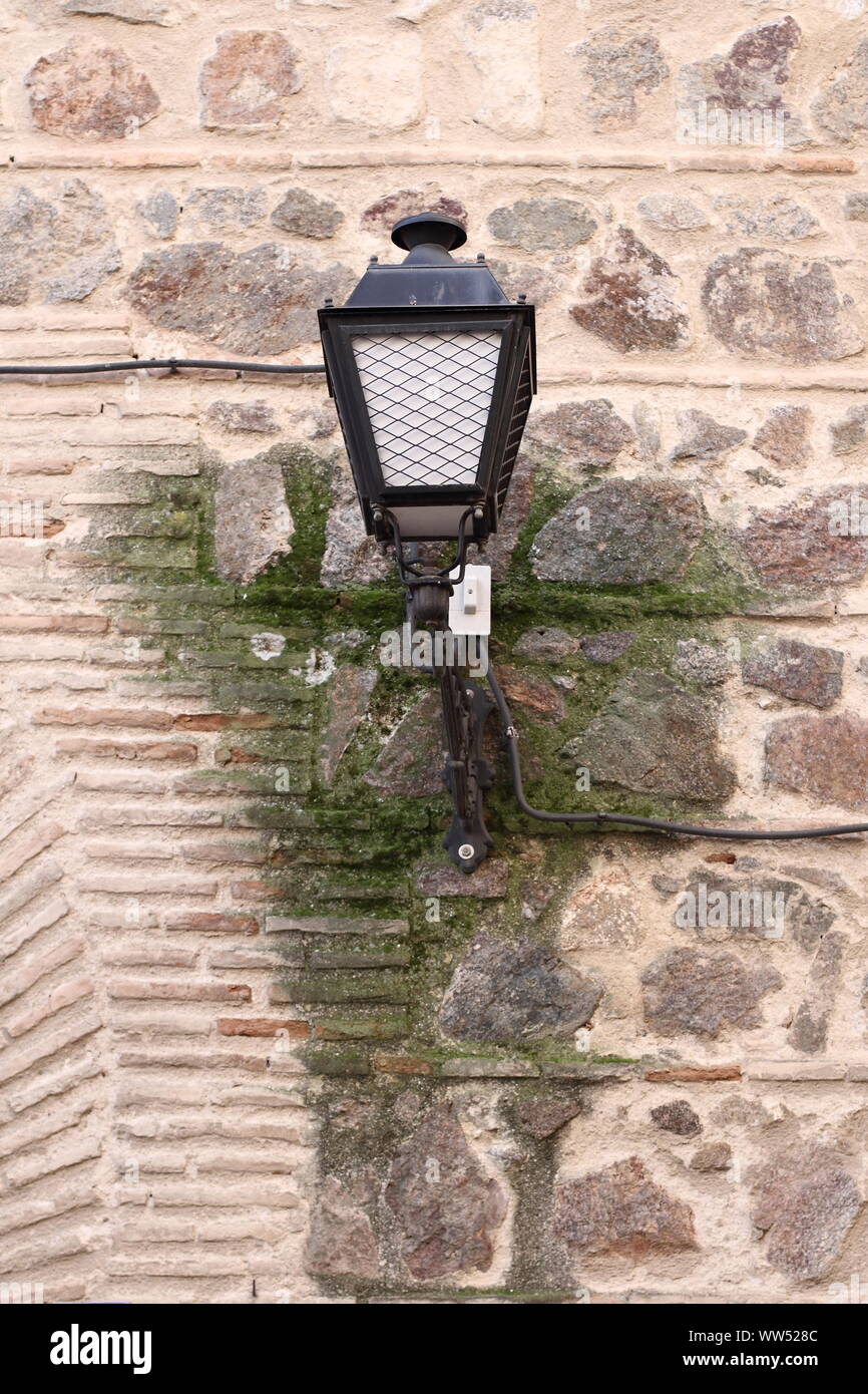 Eine alte Straßenlaterne und einen moss Fleck auf einer alten Mauer, Stockfoto