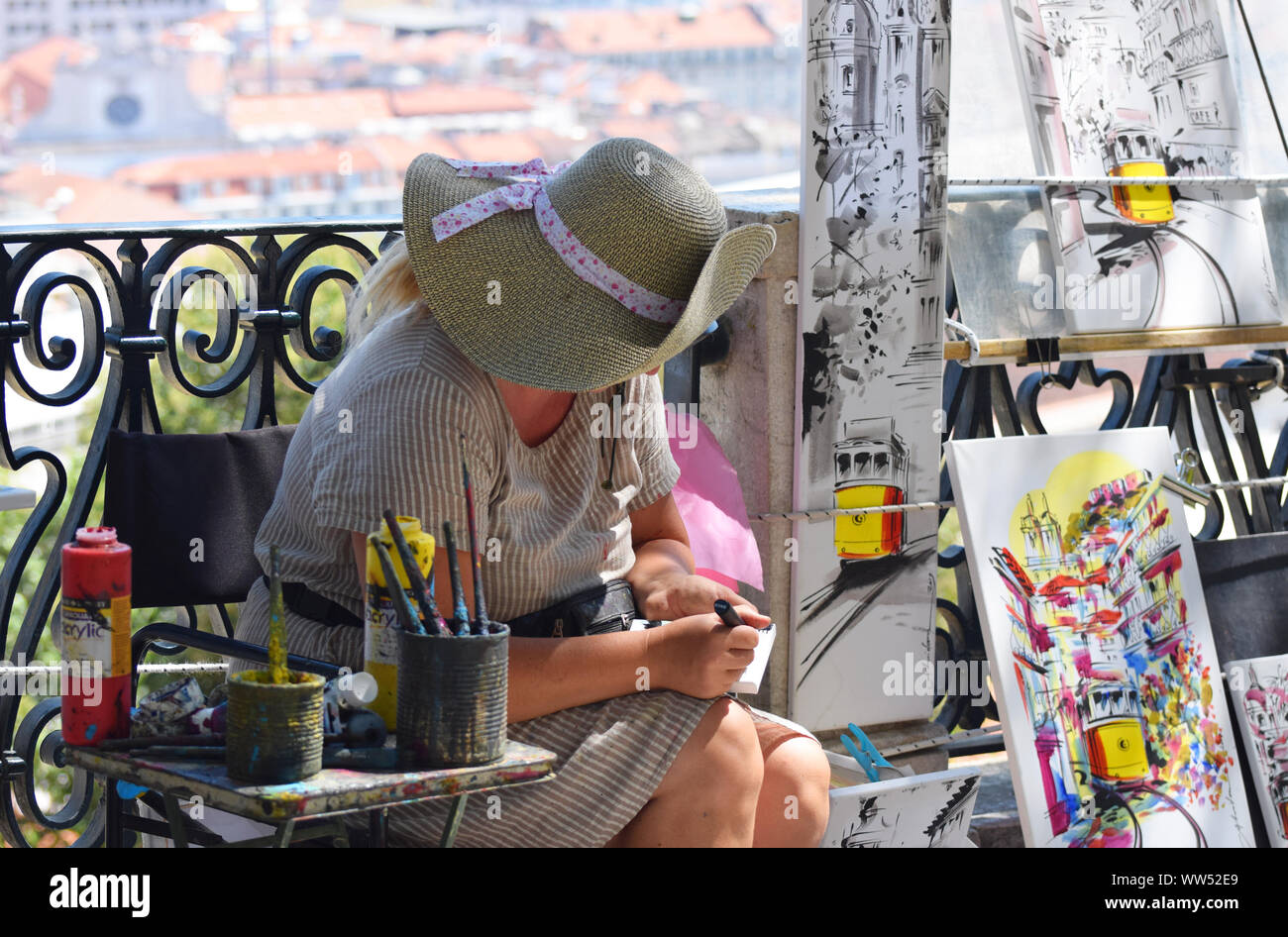 Eine Künstlerin, die ihre Originalgemälde an Touristen in Lissabon verkauft Stockfoto