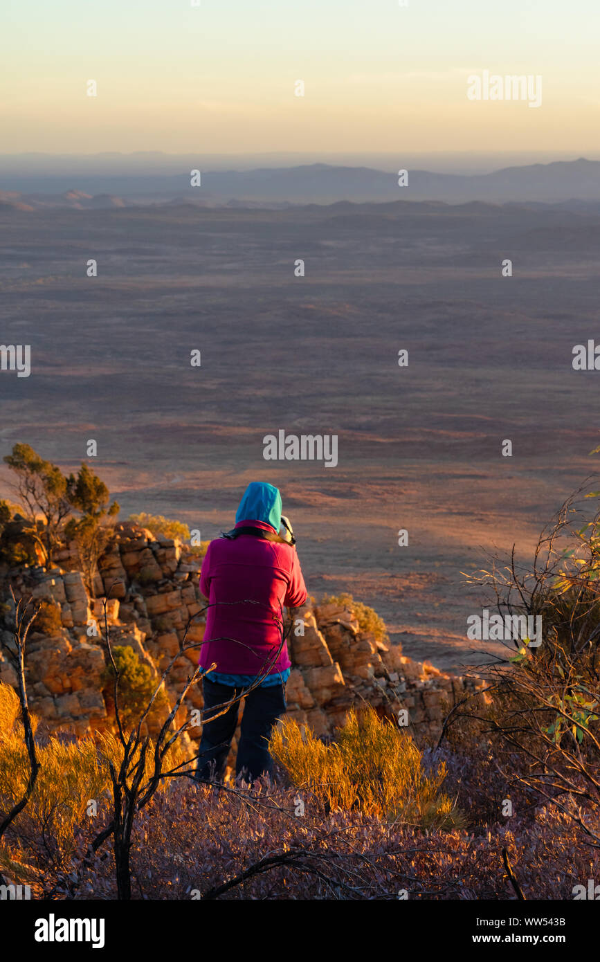 Frau stehend auf Mt Sonder ein Foto bei Sonnenaufgang, West MacDonnell National Park, Northern Territory, Australien Stockfoto