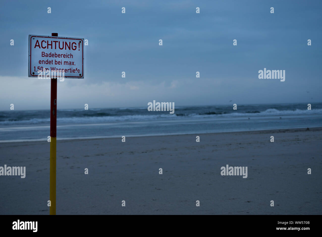 Warnschild am Strand mit Blick auf das Meer im Hintergrund Stockfoto