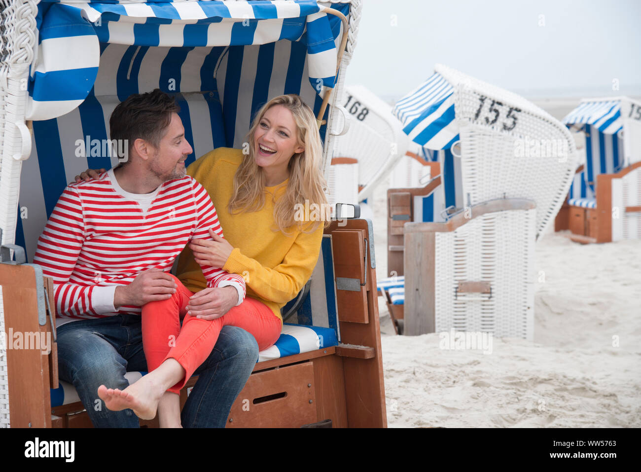 Paar lachend im Strandkorb Stockfoto