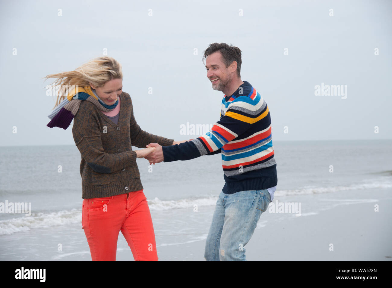 Paar hält auf und Drehen am Strand Stockfoto