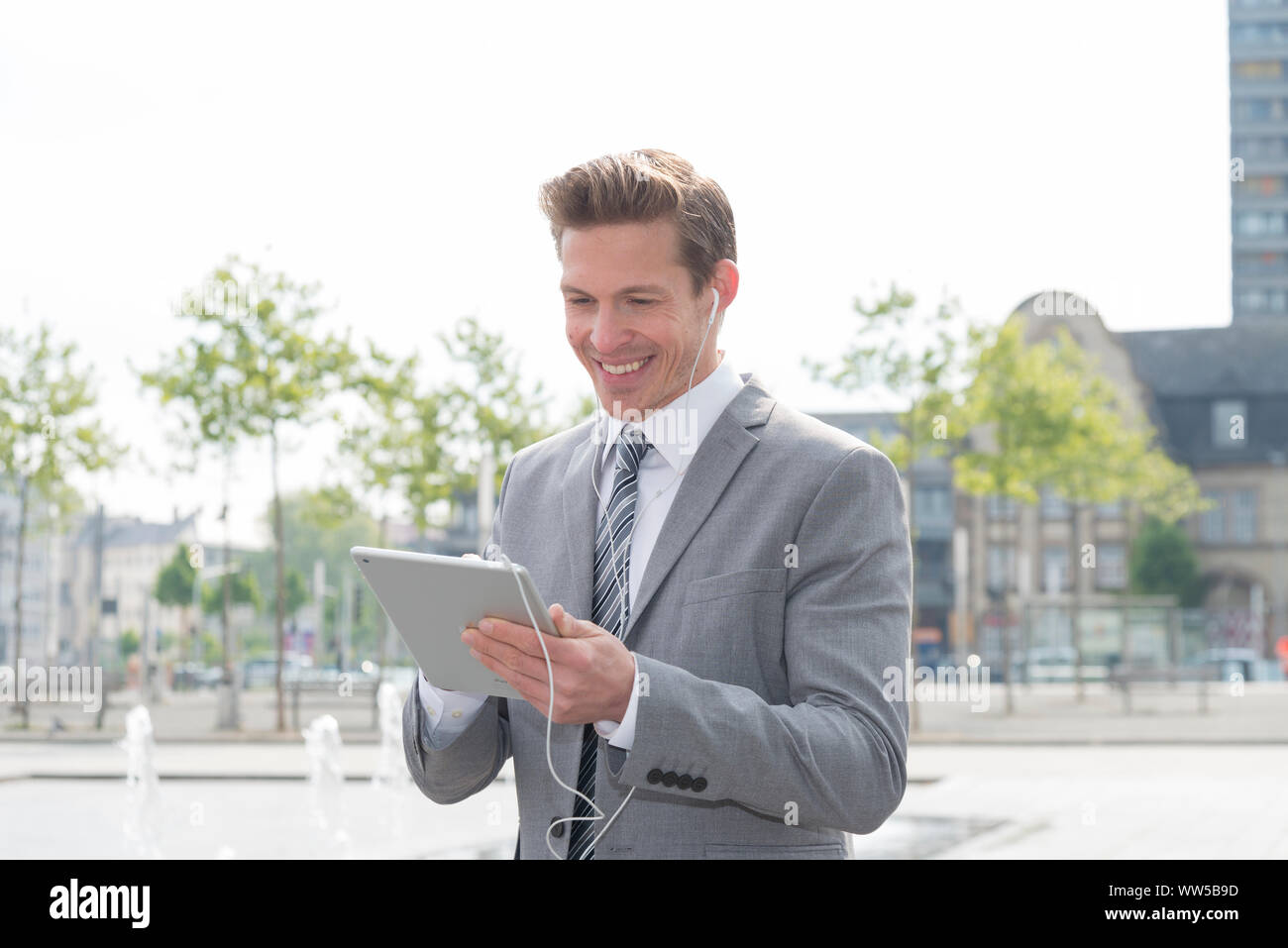 Mann in grauen Sakko mit dem iPad Stockfoto