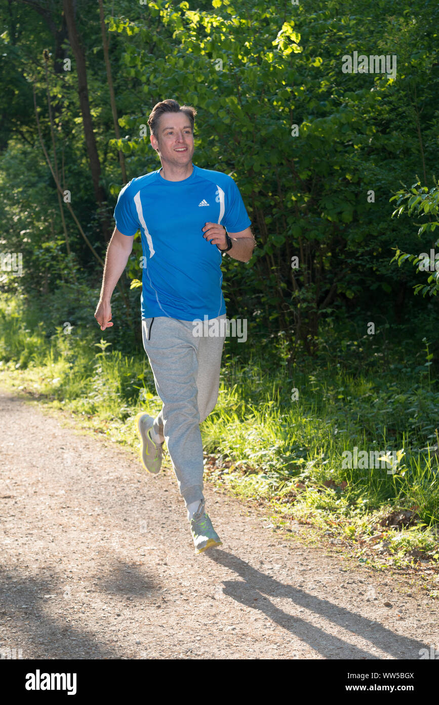 Mann im Sport Kleidung Jogging im Wald Stockfoto