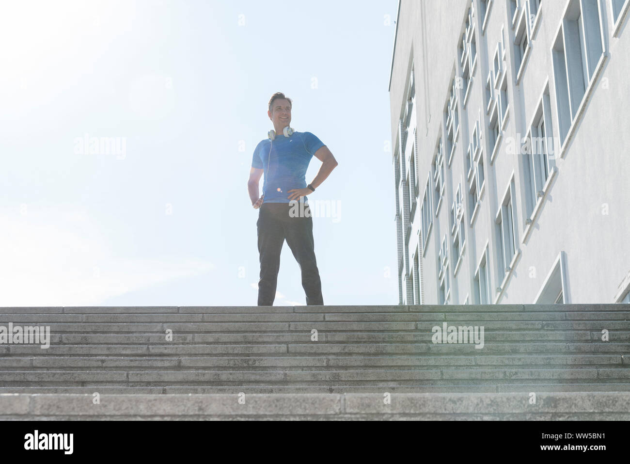 Mann im Sport Kleidung auf der Treppe außerhalb stehend Stockfoto