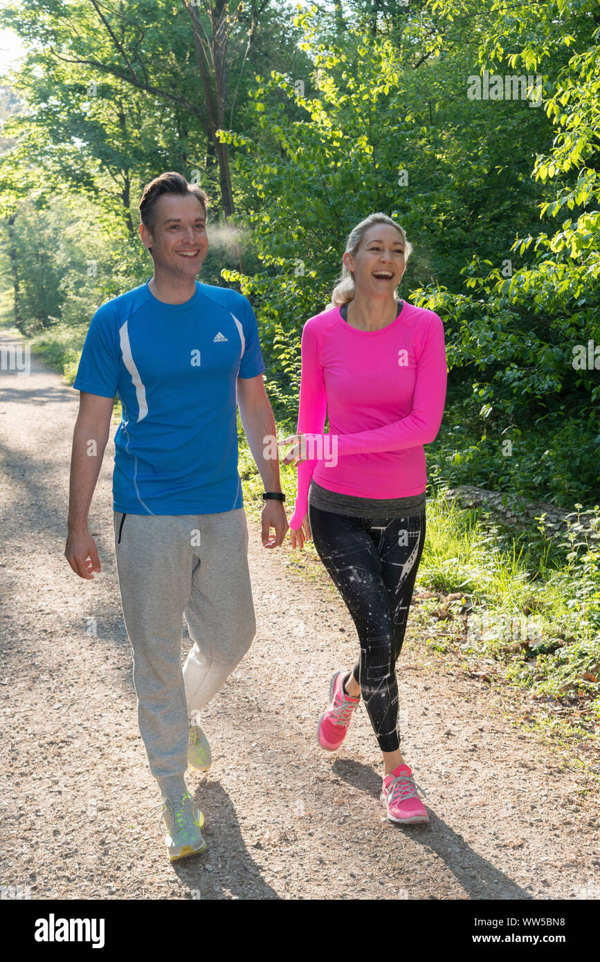 Paar in Sportswear Spaziergang im Wald lachen Stockfoto