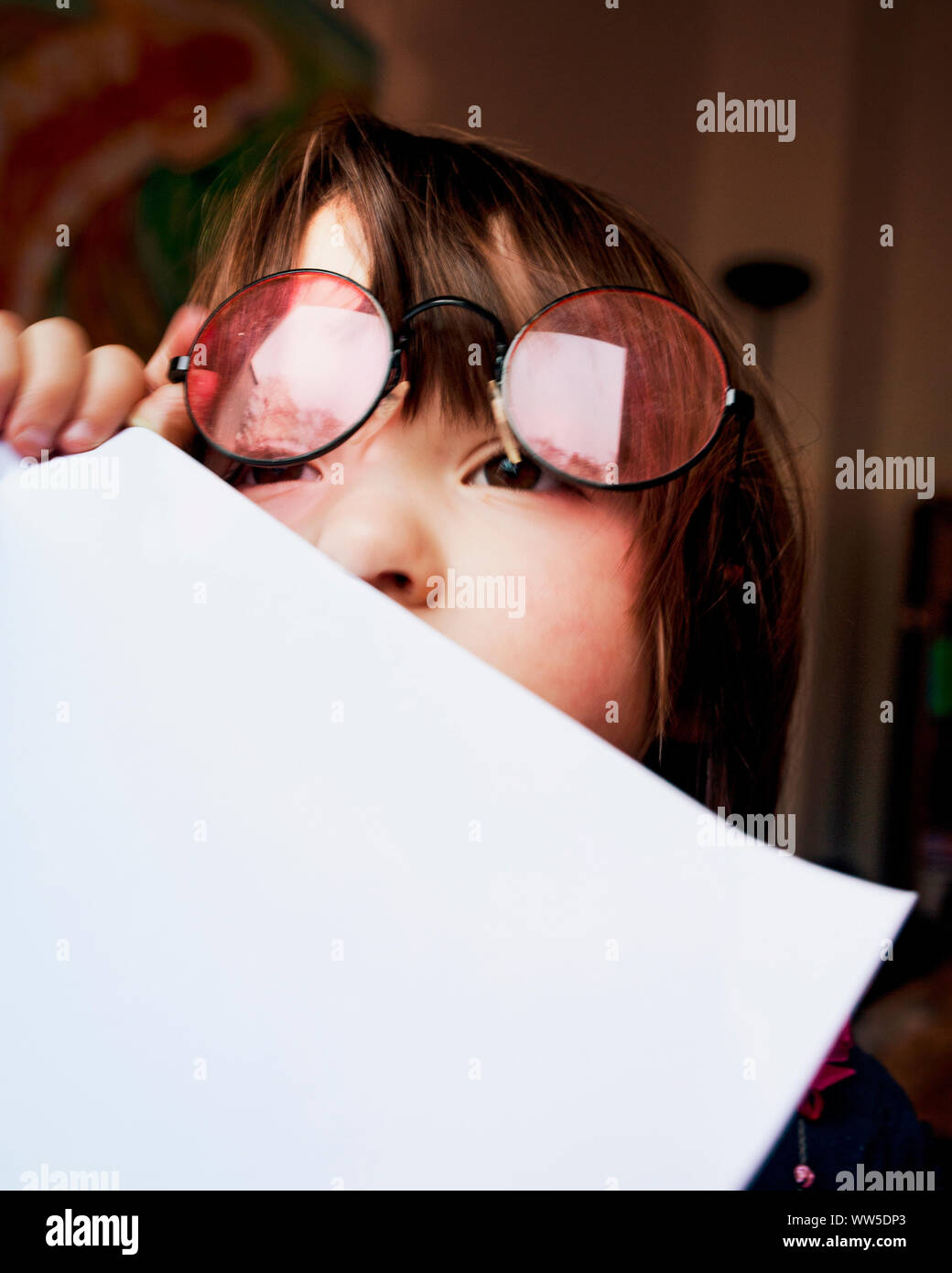 4-jähriges Kind mit Gläsern, weißen Blatt vor dem Mund Stockfoto