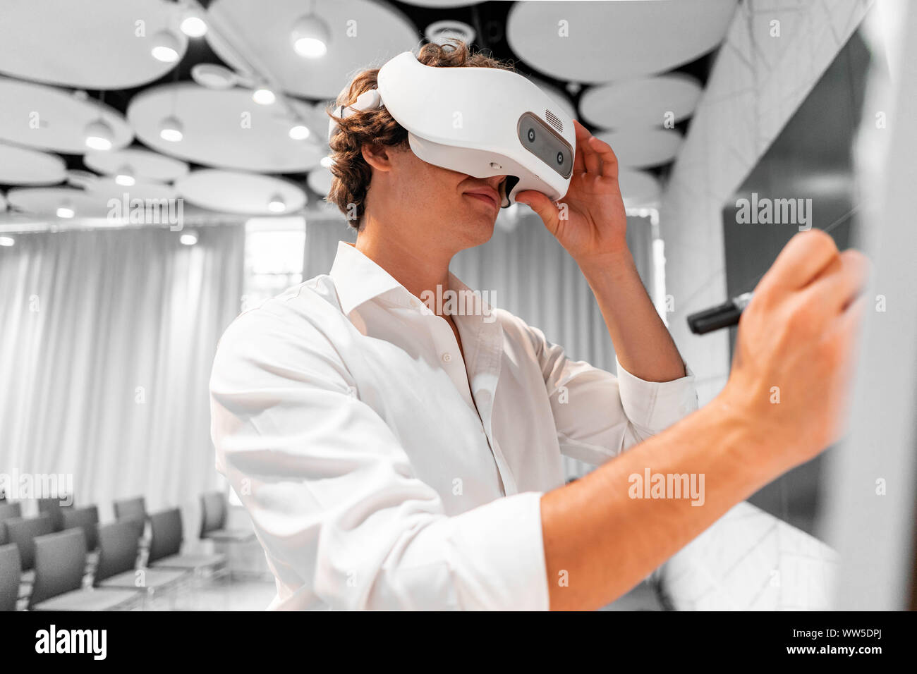 Mann mit Virtual reality Brillen mit zeitgenössischen hellen Co-working Office seine Rede an der Szene Proben ohne Zuschauer. Der VR-un Stockfoto