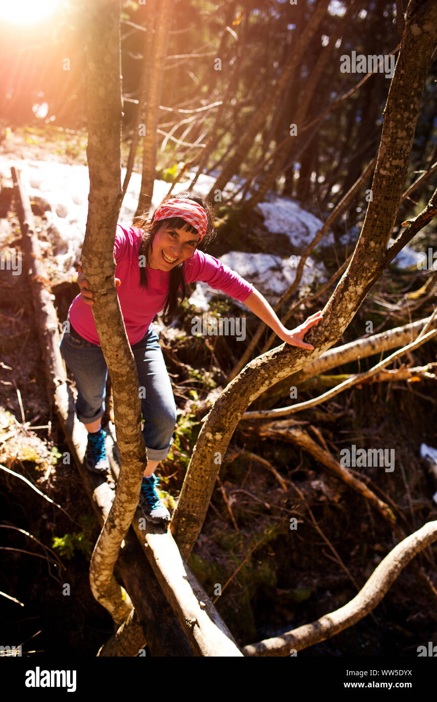 30-40 Jahre alten Frau lächelnd und Ausgleich über einen Baumstumpf Stockfoto