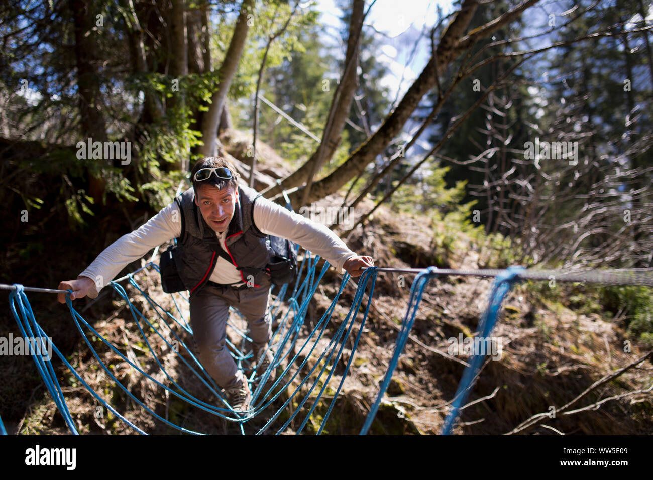 30-40 Jahre alten Mann auf Balancing Seilbrücke über eine Schlucht Stockfoto