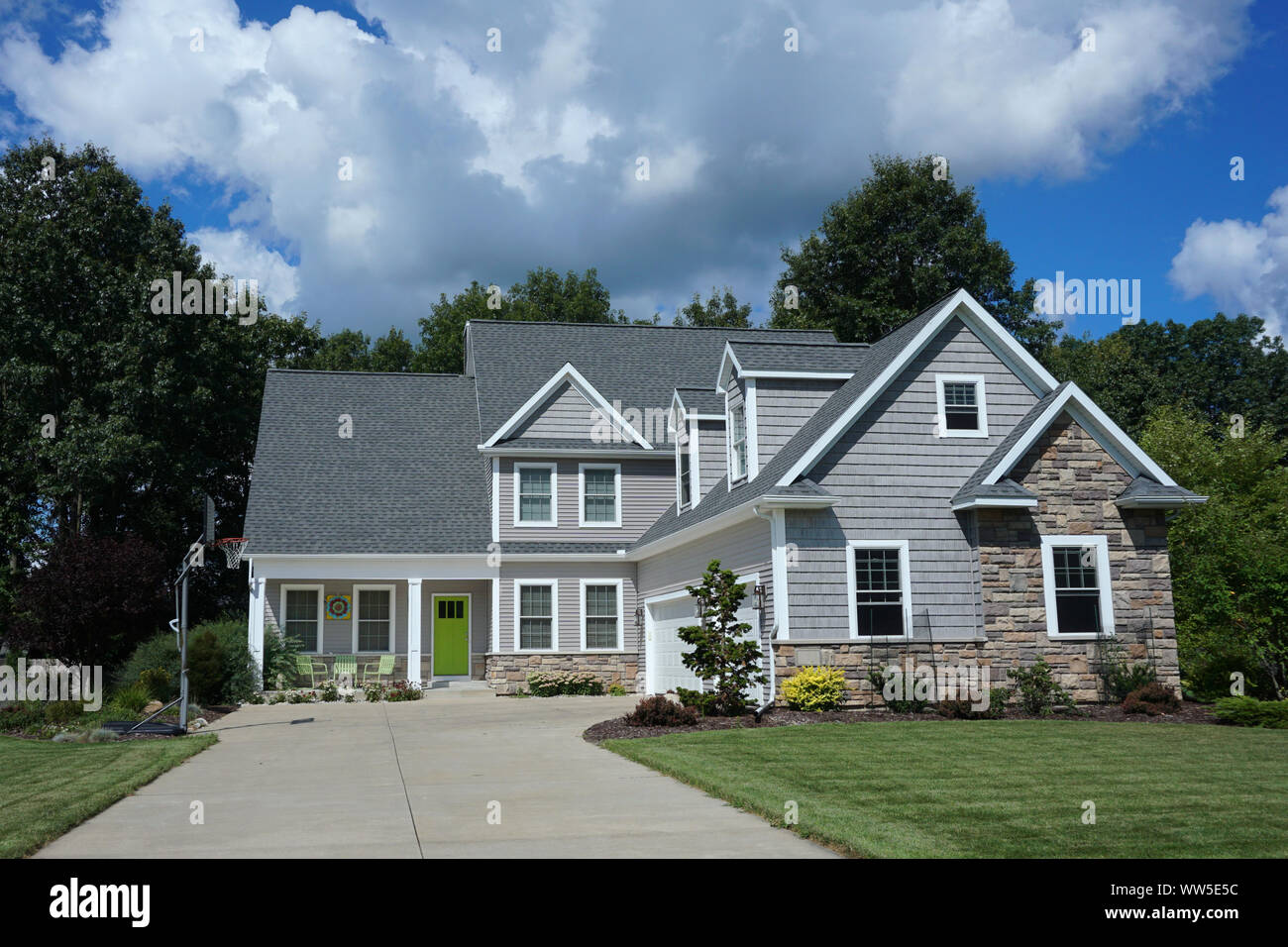 2-stöckiges Haus mit einer Einfahrt und eine grüne Tür Stockfoto