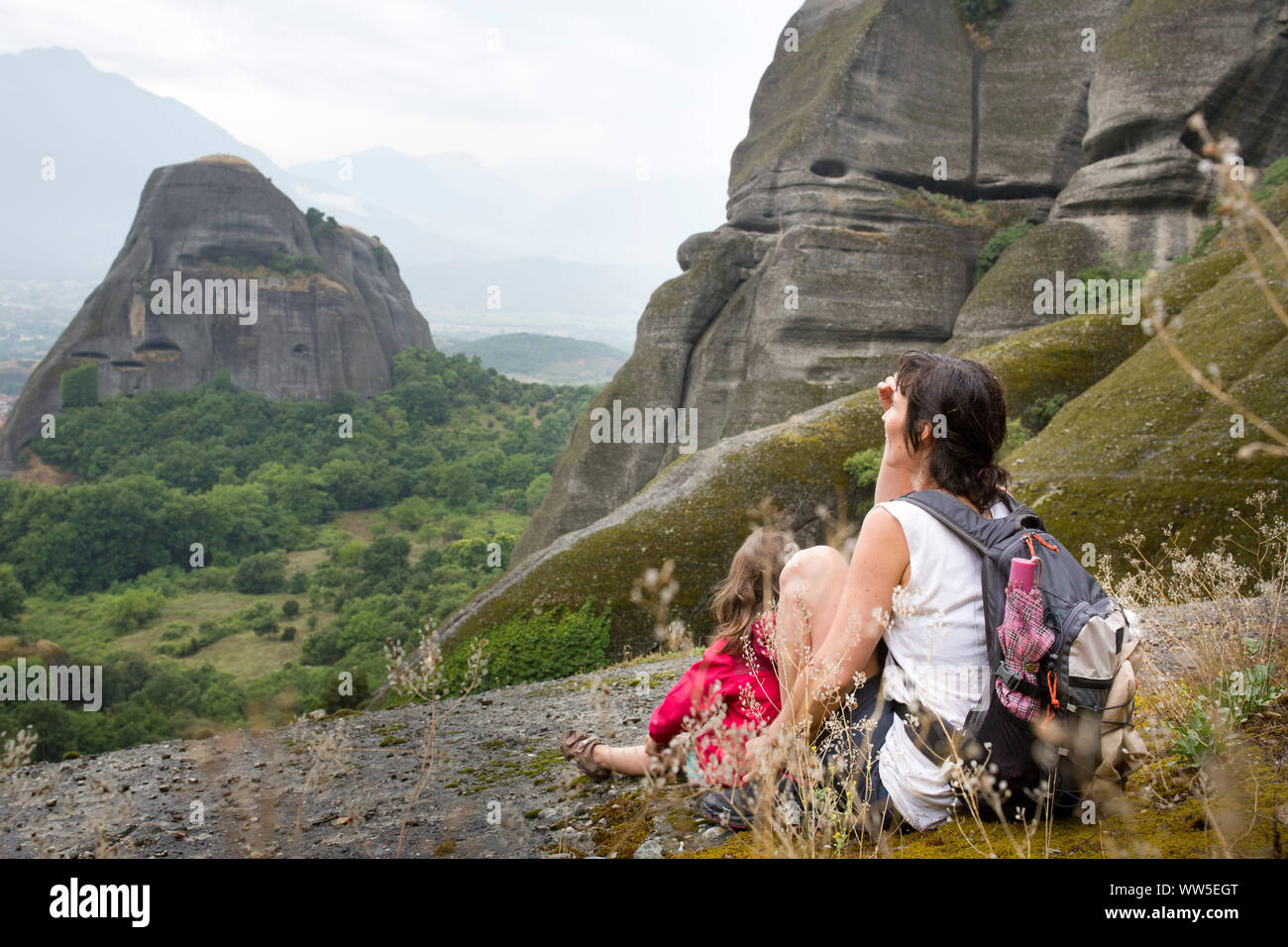 Panoramabild der felsigen Landschaft rund um Meteora mit Frau und Kind sitzen auf Leiste Stockfoto