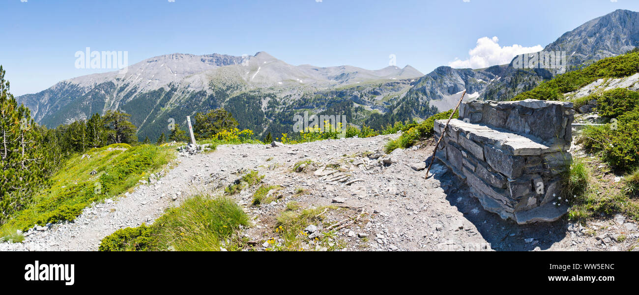 Panoramablick auf das Bild einer Steinbank am Hang, die Bergkette im Hintergrund Stockfoto
