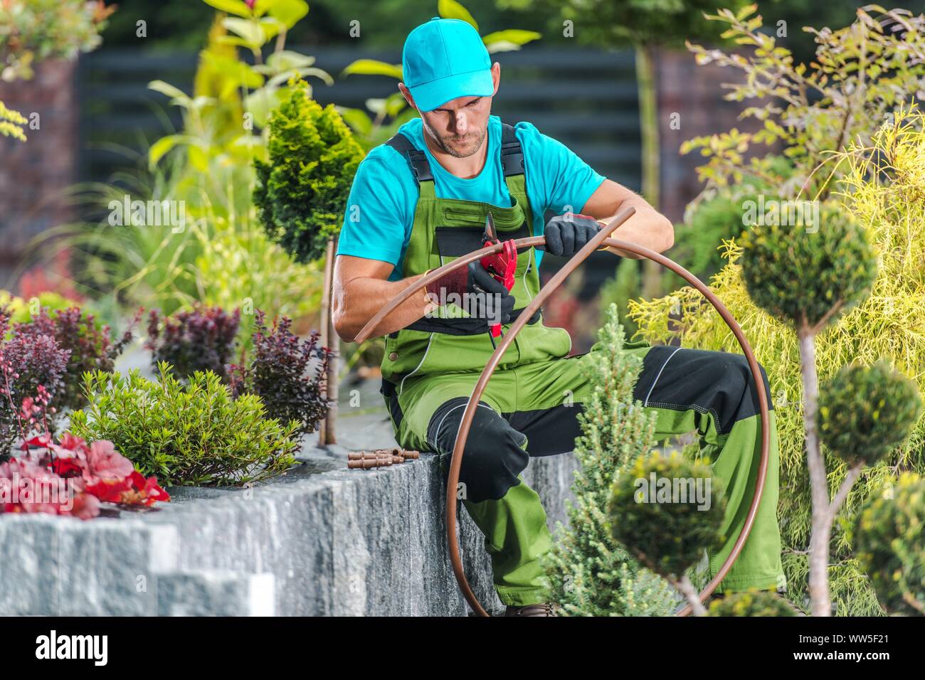 Vierzig Jahre alt kaukasischen Männern Gebäude Garten Bewässerung Bewässerungssystem. Landschaftsbau und Garten- Technologien. Stockfoto