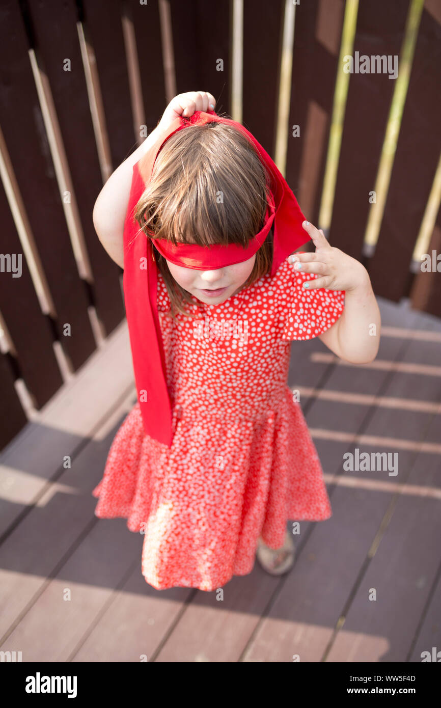 4-6 Jahre altes Mädchen im roten Kleid und rote Augen Stockfoto