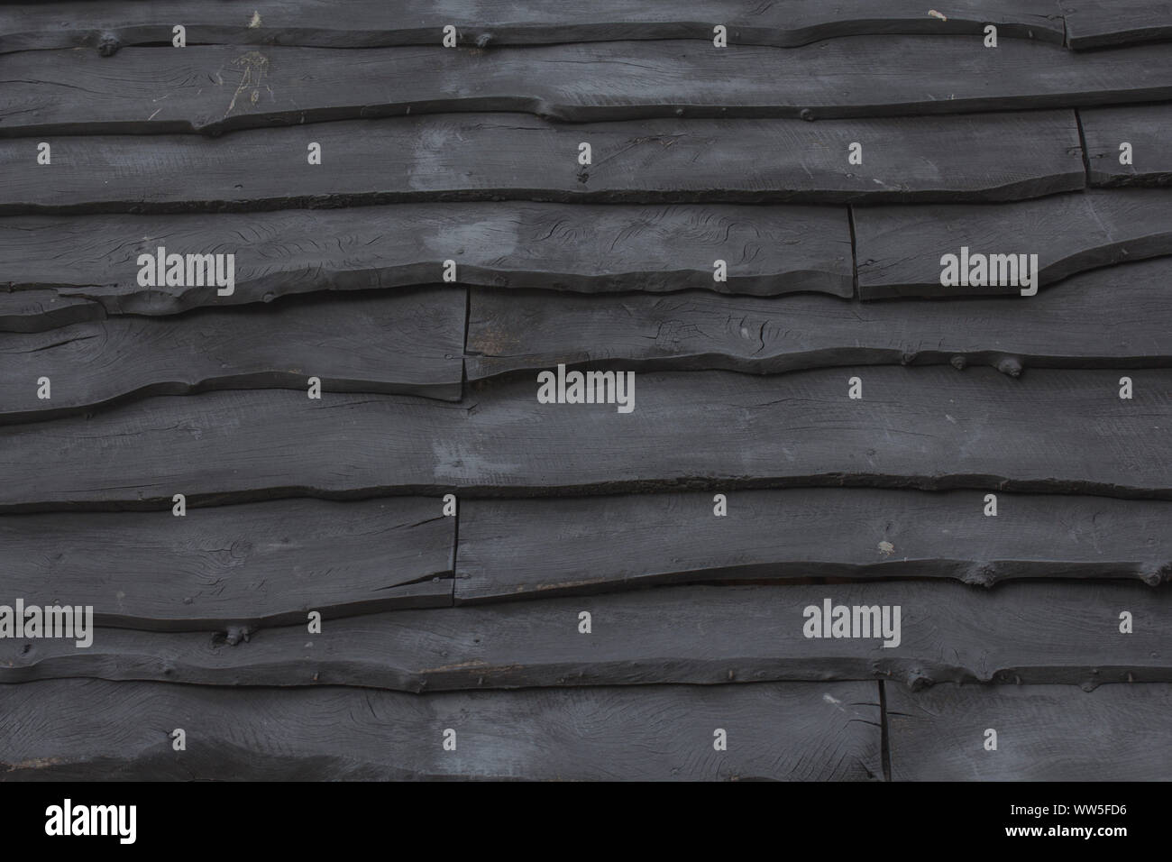 Gestapelten Brettern, ein Dach mit schwarzem Holz Schindeln, Stockfoto