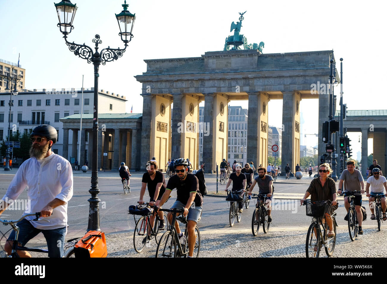 28.08.2019, Berlin, Deutschland: Radfahrer in der rush hour auf dem Platz des 18. März vor dem Brandenburger Tor am Morgen mit niedrigen Sonne in der Stockfoto