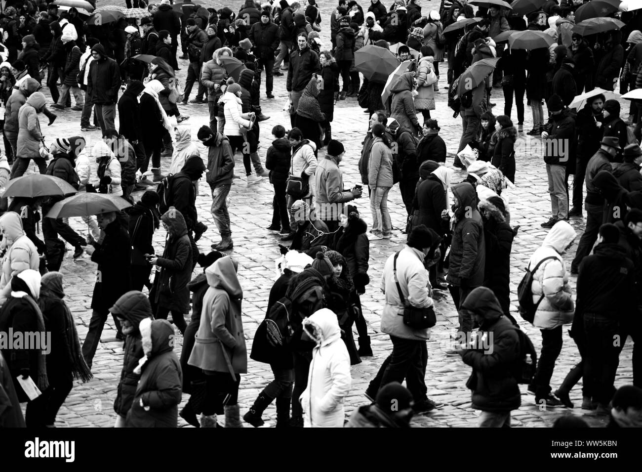 Touristen stehen und gehen im regnerischen Wetter auf dem Platz des Palastes von Versailles, Stockfoto