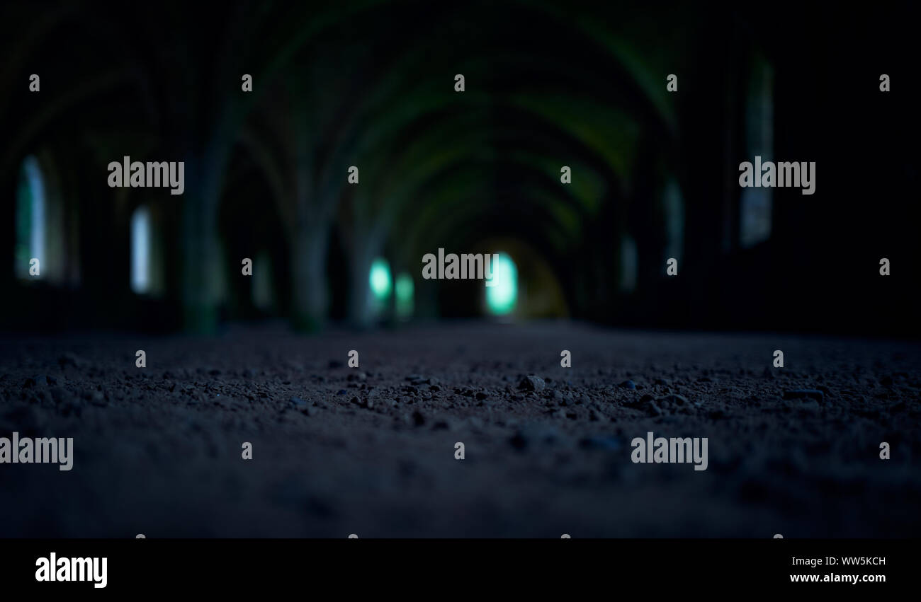 Der Kiesboden und Bögen von einem Dungeon in einem alten Kloster, Burg bei Nacht. Stockfoto