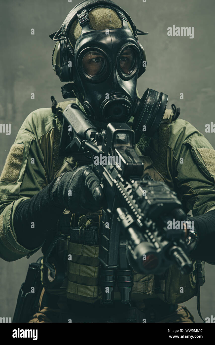 Spezielle Einheit Soldat mit Gasmaske und taktische Ausrüstung hält Sturmgewehr Stockfoto