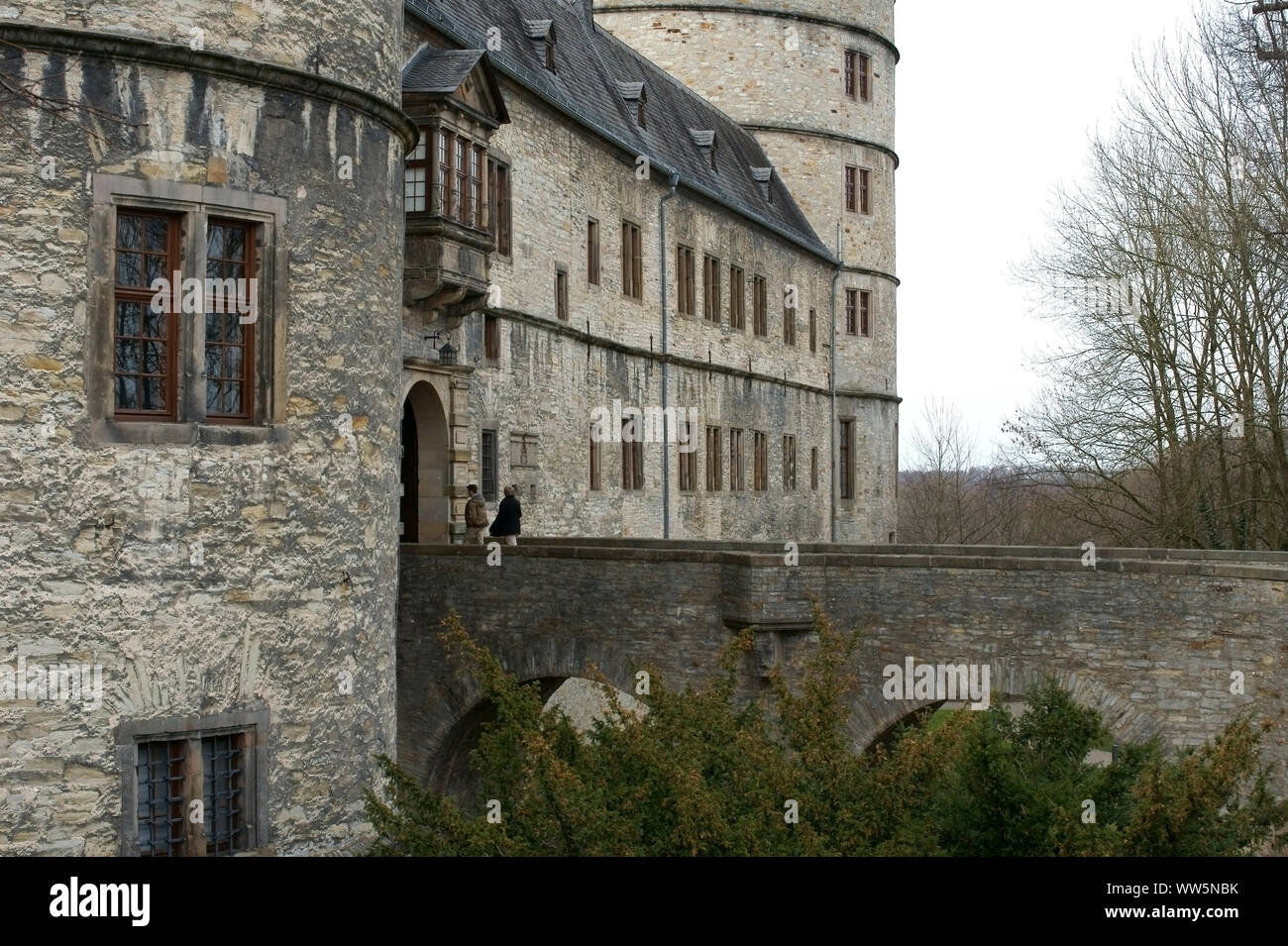 Zwei Menschen laufen über eine Brücke in Richtung der Wewelsburg in BÃ¼ren, Stockfoto